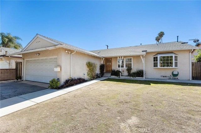 ranch-style home with aphalt driveway, fence, a garage, and stucco siding