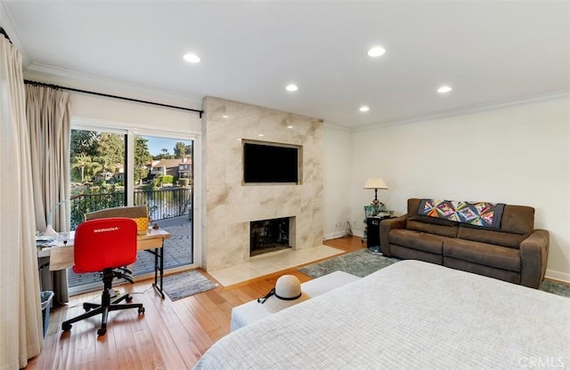 bedroom with recessed lighting, wood finished floors, a high end fireplace, access to exterior, and ornamental molding