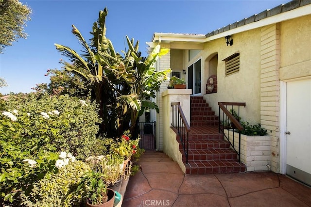 entrance to property with brick siding and stucco siding