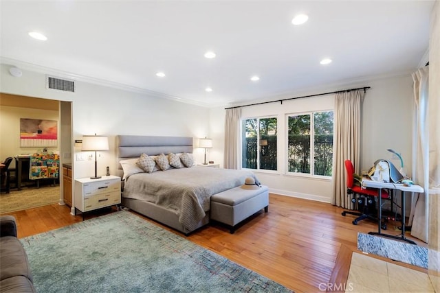 bedroom featuring light wood-style floors, recessed lighting, visible vents, and ornamental molding