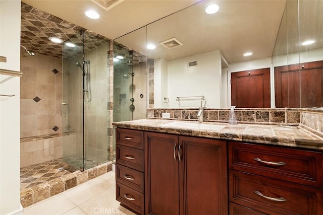 bathroom featuring visible vents, a stall shower, tile patterned flooring, and vanity