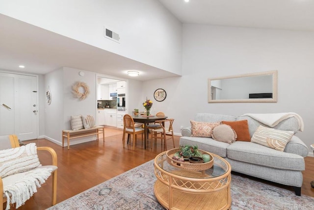 living area featuring recessed lighting, visible vents, baseboards, and wood finished floors