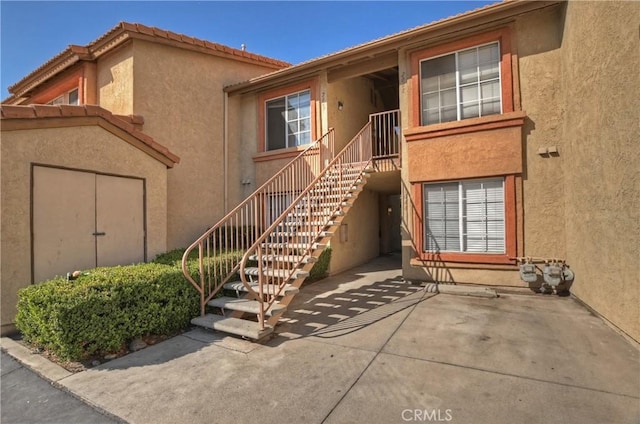 property entrance with a patio and stucco siding