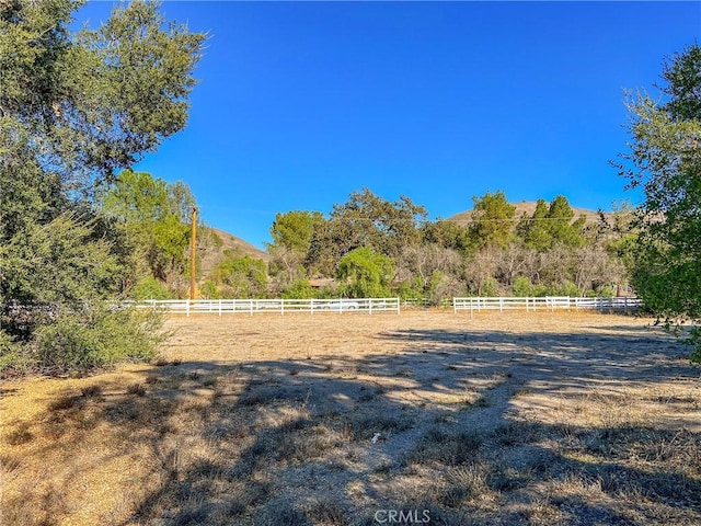 view of yard with a rural view and fence