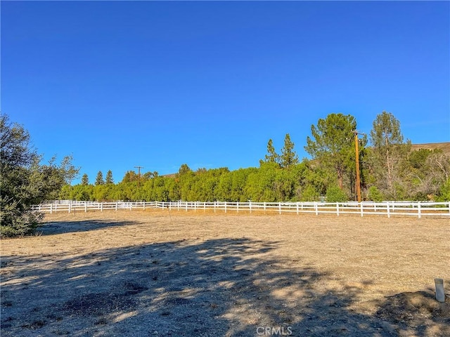 view of yard featuring a rural view and fence