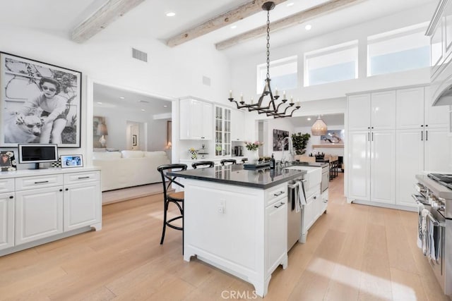 kitchen featuring light wood finished floors, a breakfast bar area, and white cabinets