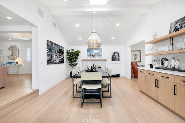 dining space featuring light wood-style floors, visible vents, vaulted ceiling with beams, and baseboards