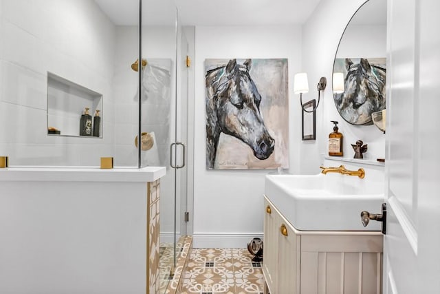 bathroom featuring tile patterned floors, a shower stall, vanity, and baseboards