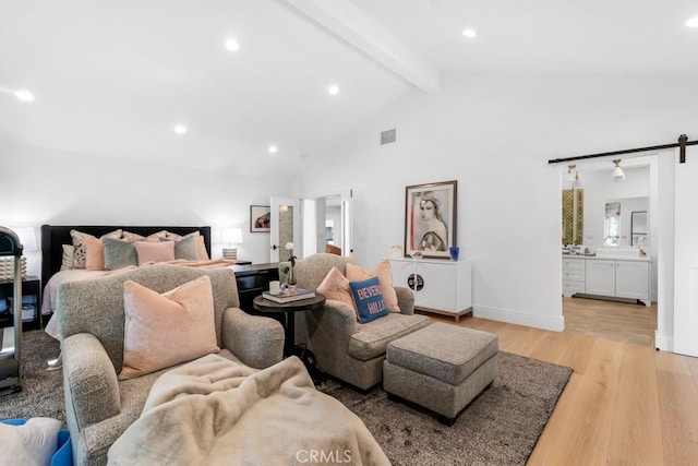 bedroom featuring beam ceiling, recessed lighting, ensuite bathroom, light wood-type flooring, and baseboards