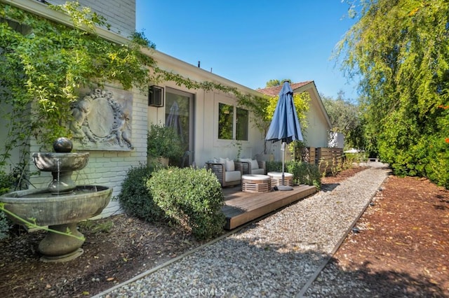 back of house with a deck, brick siding, and outdoor lounge area