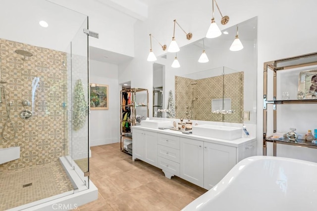 bathroom featuring double vanity, a soaking tub, a shower stall, and a sink