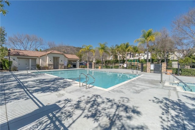 pool featuring fence and a patio