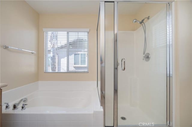 bathroom featuring a stall shower and a garden tub