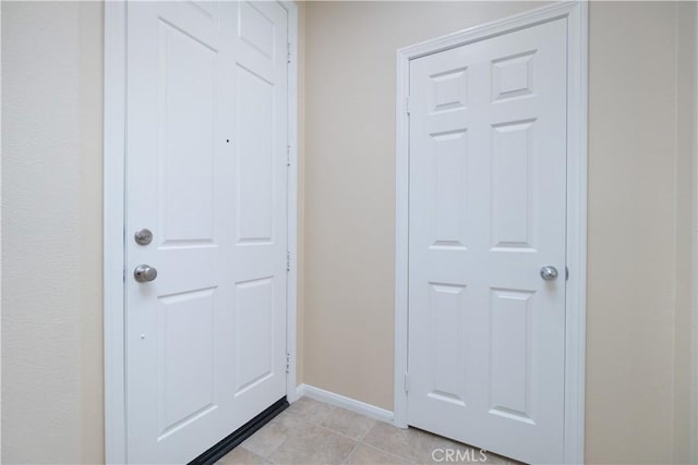 entryway with light tile patterned floors and baseboards