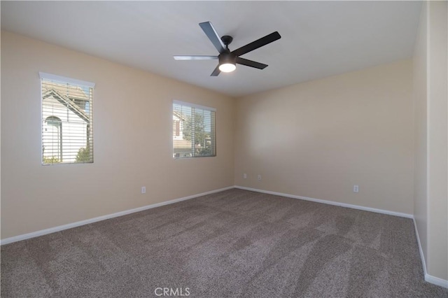 carpeted spare room featuring ceiling fan and baseboards