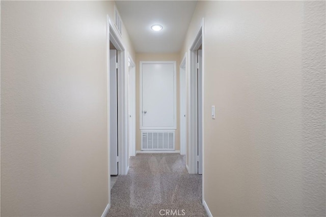 corridor featuring carpet, visible vents, and baseboards