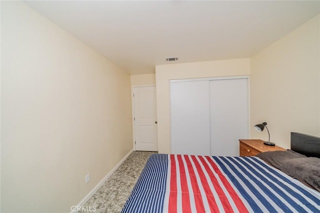 carpeted bedroom featuring baseboards, visible vents, and a closet