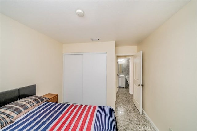 bedroom with baseboards, visible vents, and a closet