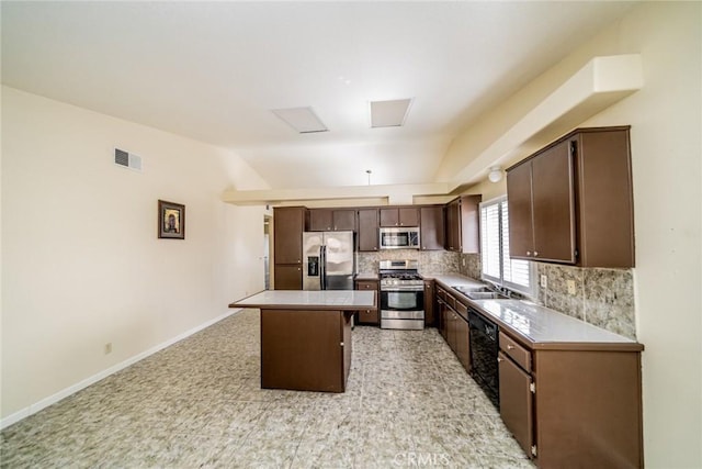 kitchen featuring decorative backsplash, a kitchen island, appliances with stainless steel finishes, dark brown cabinets, and a sink