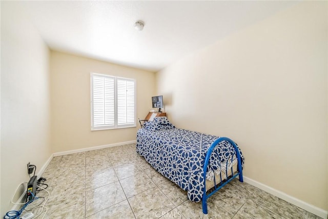 tiled bedroom featuring baseboards