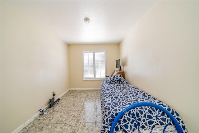 bedroom featuring light tile patterned floors and baseboards