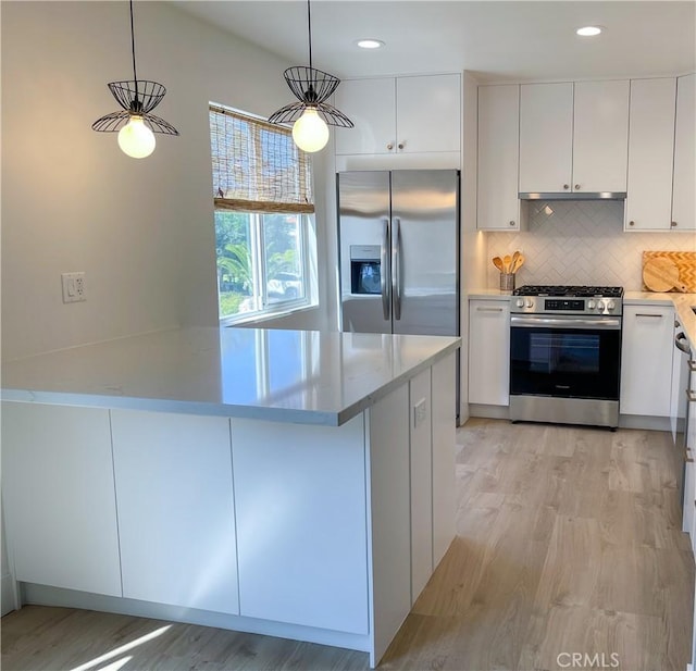 kitchen featuring white cabinetry, appliances with stainless steel finishes, light wood-type flooring, decorative backsplash, and decorative light fixtures