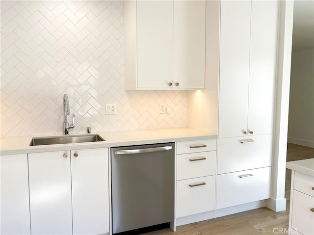 kitchen featuring a sink, white cabinets, stainless steel dishwasher, and light countertops