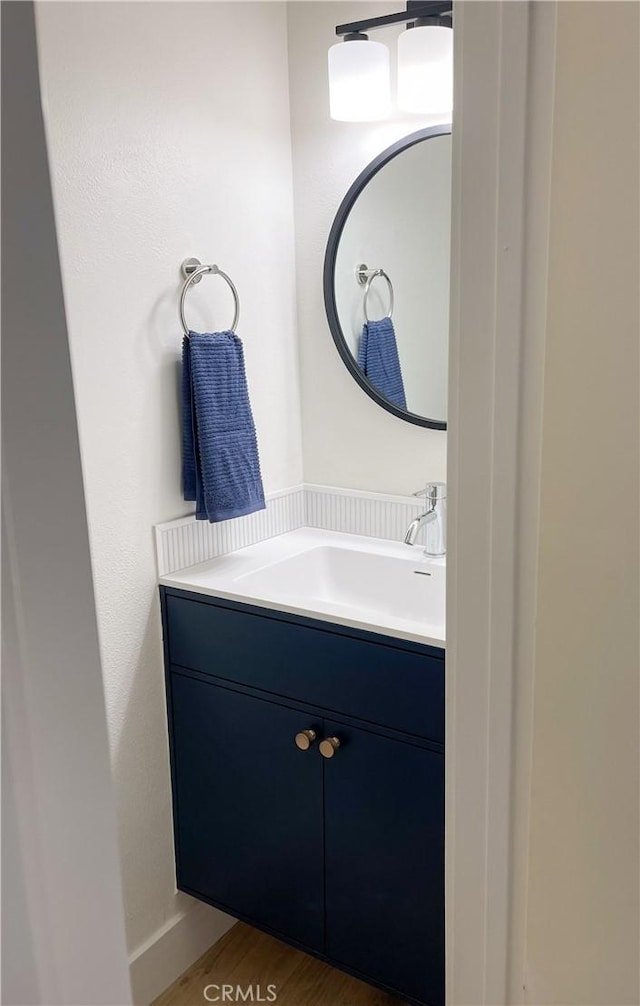 bathroom with wood finished floors and vanity