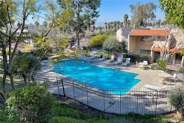 pool featuring fence and a patio