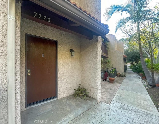 view of exterior entry featuring stucco siding