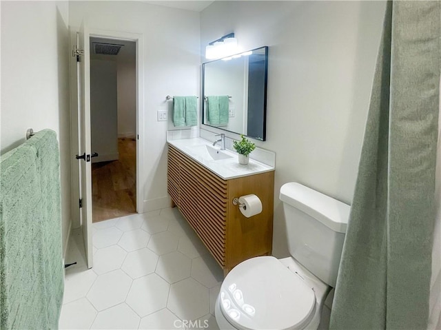 bathroom featuring tile patterned flooring, visible vents, vanity, and toilet