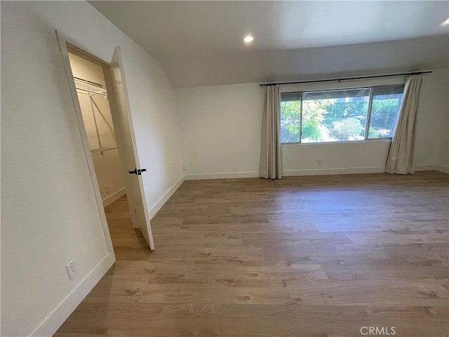 unfurnished room featuring recessed lighting, wood finished floors, and baseboards