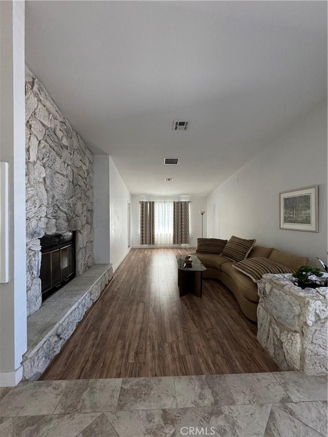 unfurnished living room with a fireplace, wood finished floors, and visible vents