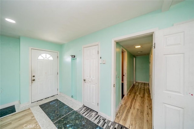 entryway with baseboards and wood finished floors