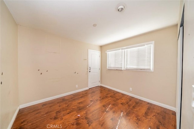 unfurnished room featuring baseboards and wood finished floors