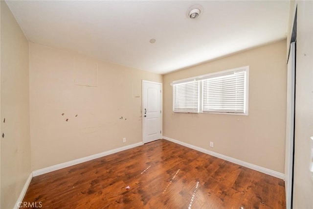 unfurnished room featuring wood finished floors and baseboards