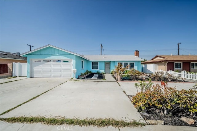 ranch-style home with board and batten siding, fence, driveway, and an attached garage