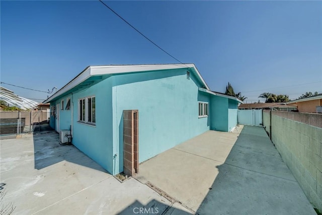 view of property exterior with fence private yard, a patio area, and stucco siding