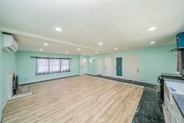 kitchen featuring a wall mounted air conditioner, wood finished floors, and recessed lighting