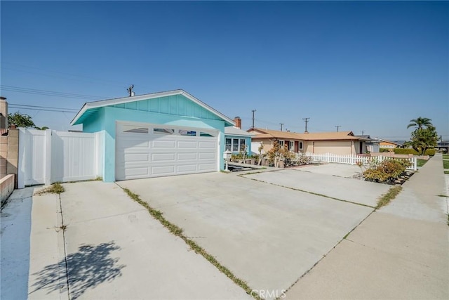 garage featuring fence and concrete driveway