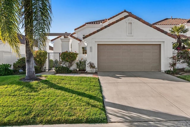 mediterranean / spanish home with an attached garage, a tile roof, concrete driveway, and a front yard