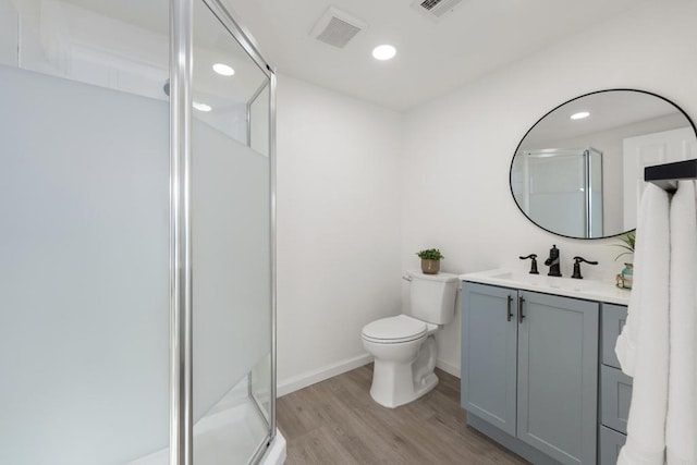 full bathroom with toilet, wood finished floors, a shower stall, and visible vents