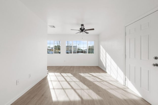 unfurnished room with visible vents, baseboards, and wood finished floors