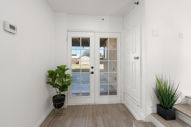 doorway to outside featuring french doors, wood finished floors, and baseboards