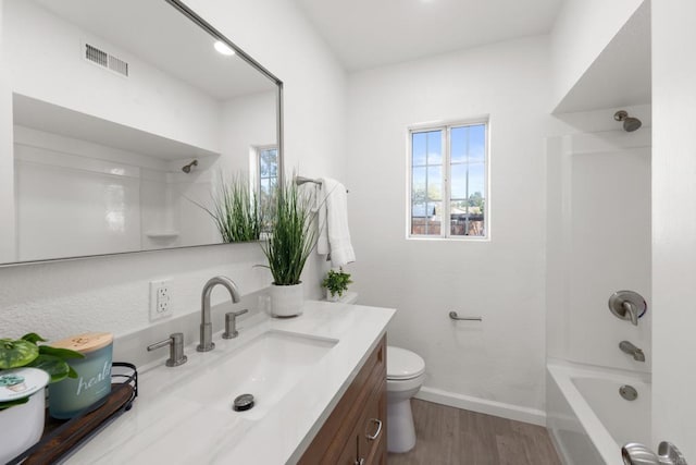 full bathroom with toilet, wood finished floors, vanity, visible vents, and baseboards