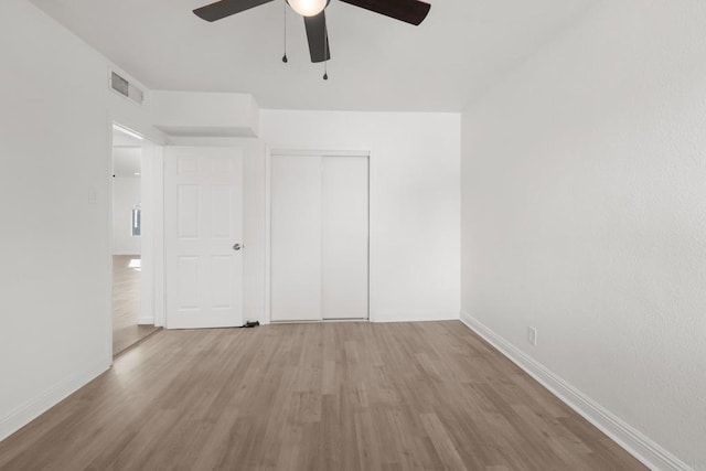 unfurnished room with visible vents, baseboards, and wood finished floors