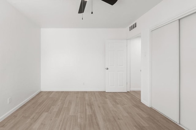 interior space featuring light wood-style floors, ceiling fan, visible vents, and baseboards