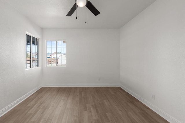 spare room featuring ceiling fan, wood finished floors, and baseboards