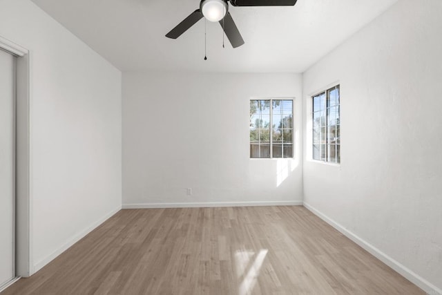 unfurnished room with a ceiling fan, baseboards, and light wood finished floors