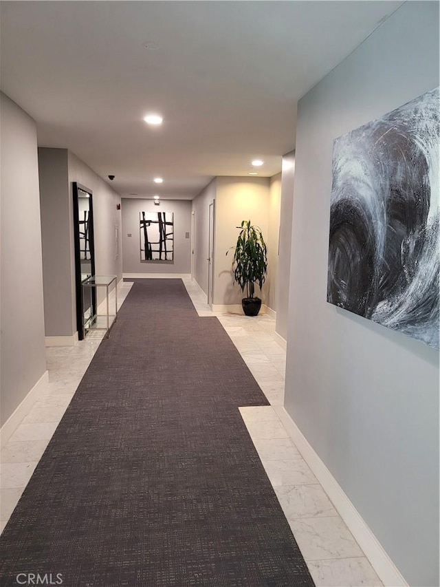 hallway featuring recessed lighting, marble finish floor, and baseboards